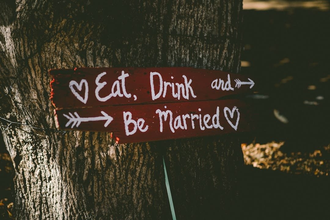 Rustic wooden wedding sign reading Eat, Drink and Be Married tied to a tree. Transform your big day.