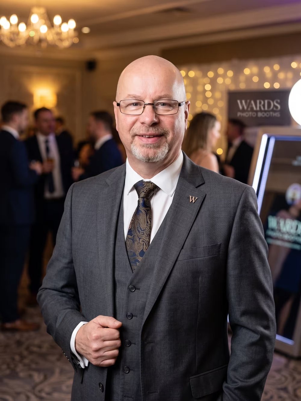 Mark Rogers of Wards Photo Booths smiling beside the Magic Mirror photo booth at a wedding reception