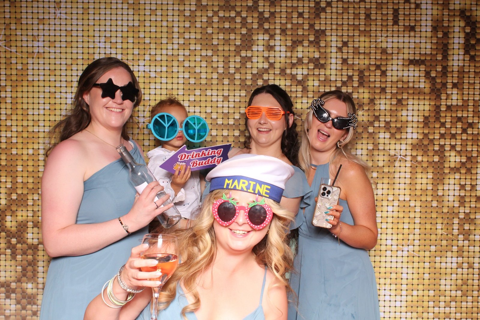 Bridesmaids wearing fun novelty sunglasses and prop hats at a Wolverhampton wedding photo booth