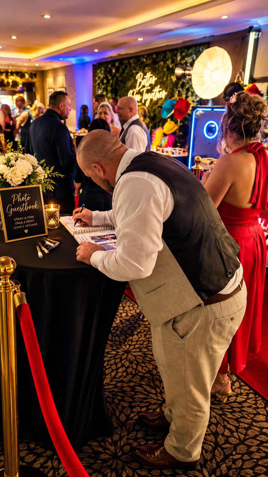 Wedding guest writing a message in a luxury slip-in guestbook at a Wards Photo Booths reception in the West Midlands